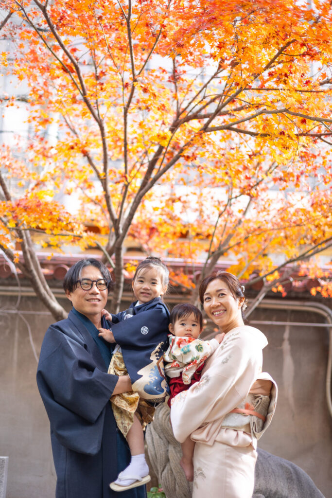 紅葉の季節に七五三の参拝をする家族