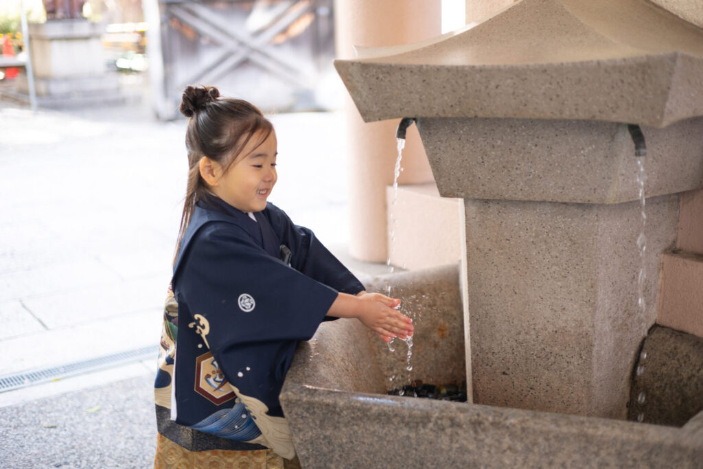 七五三のお参りで大阪の神社の手水舎を使う子ども