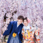 枝垂れ桜の下で和装フォトウェディングを撮影する新郎新婦