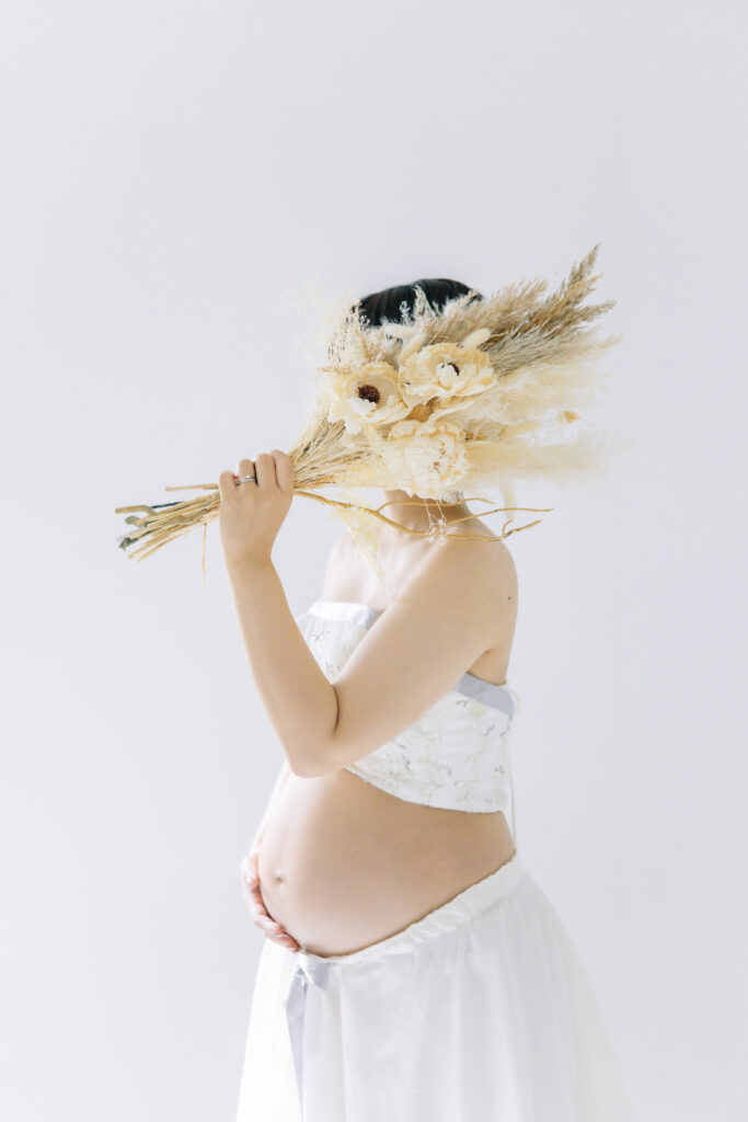 ブーケを持ってマタニティフォトを撮影する花嫁