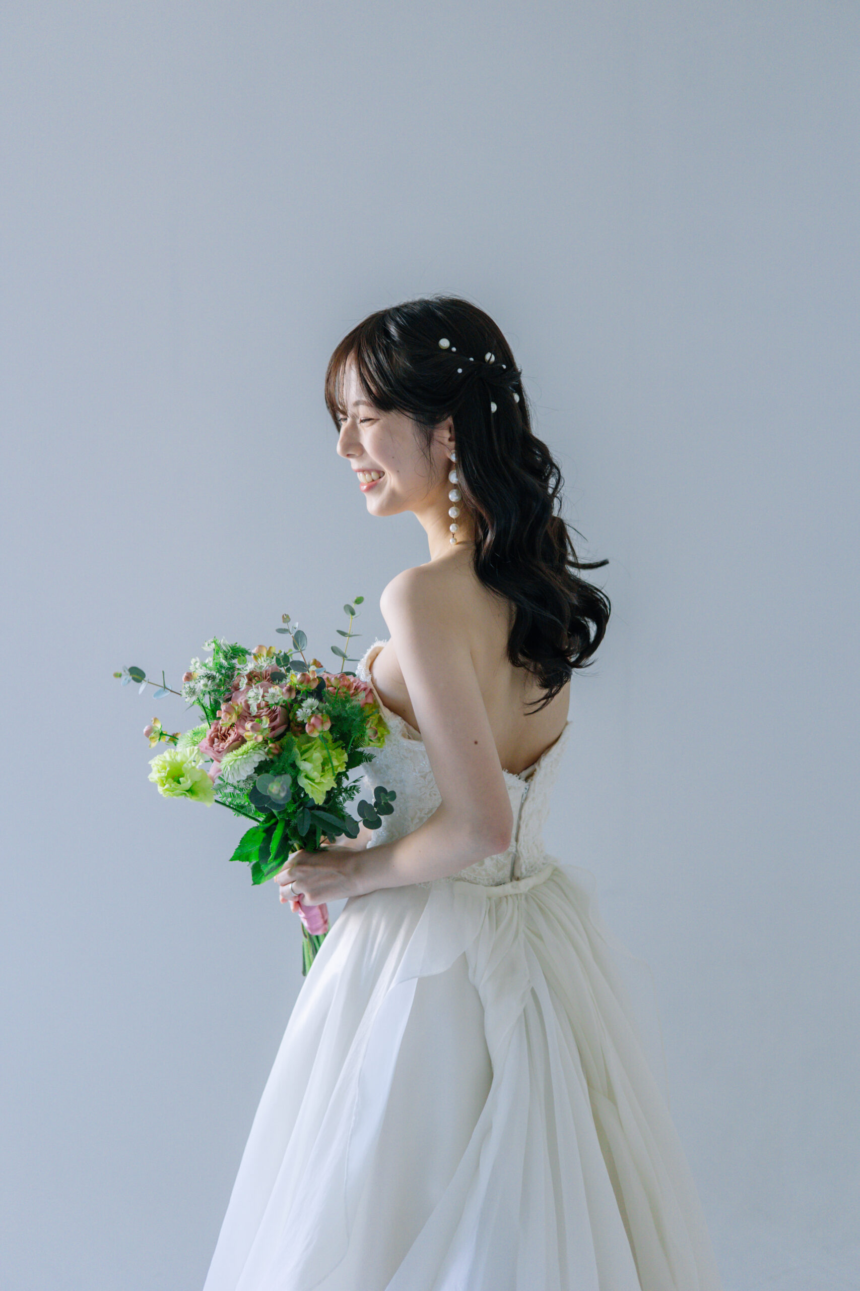 ダウンスタイルにパールヘアアクセでフォトウェディングを撮影する女性