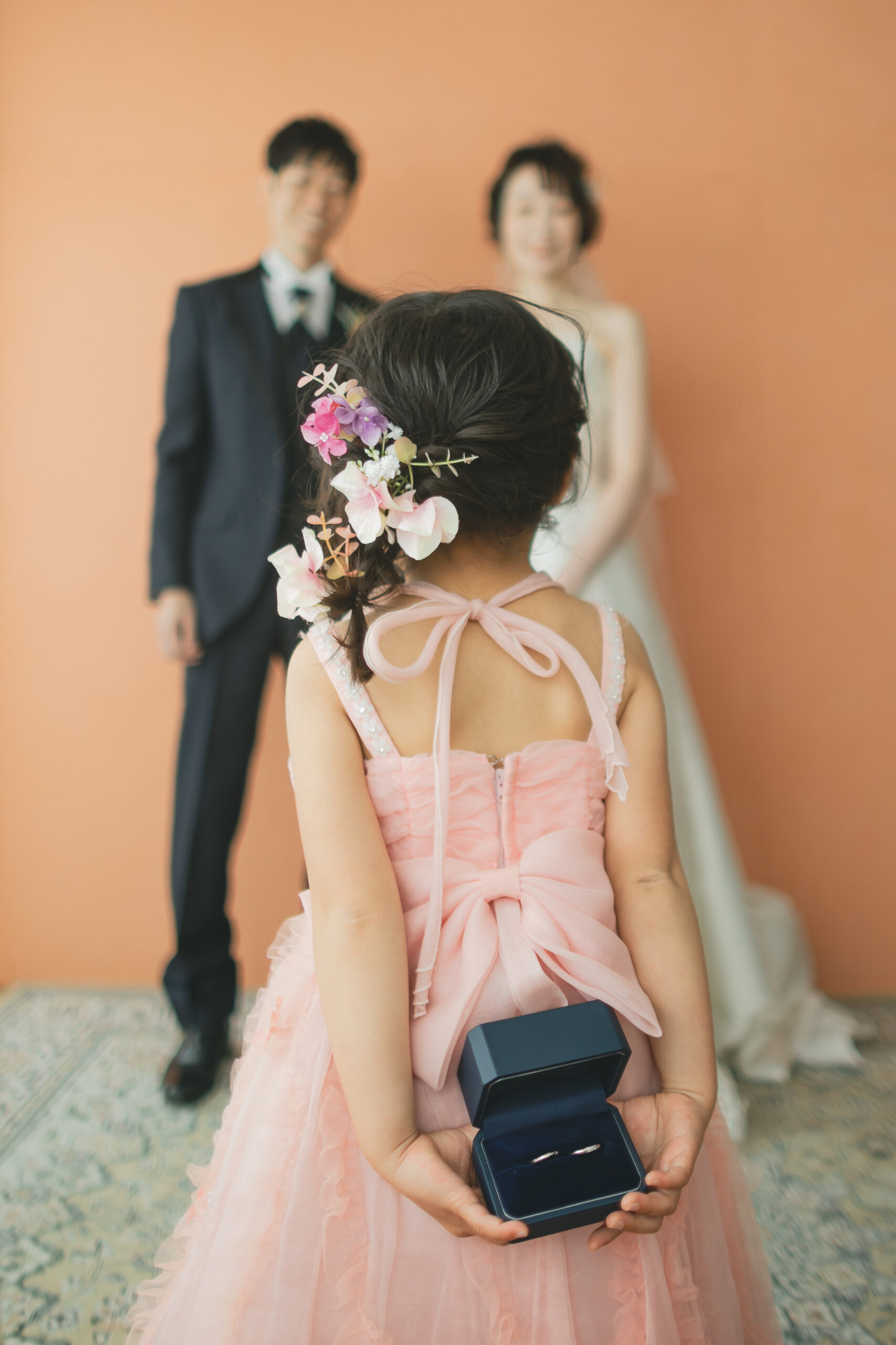 家族フォトウェディングにて新郎新婦の前でリングガールをつとめる女の子