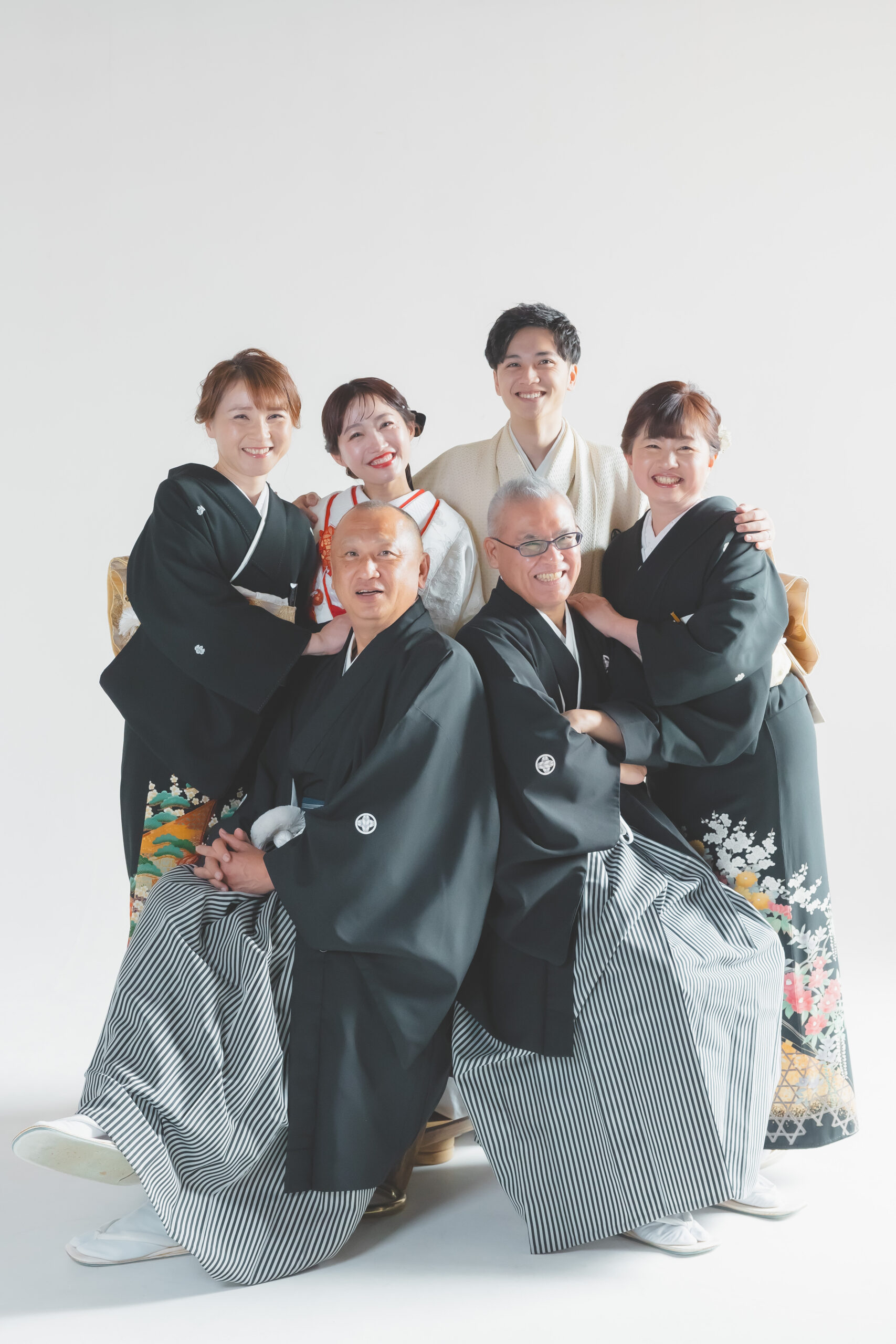 両親と一緒に正装でフォトウェディングをする新郎新婦
