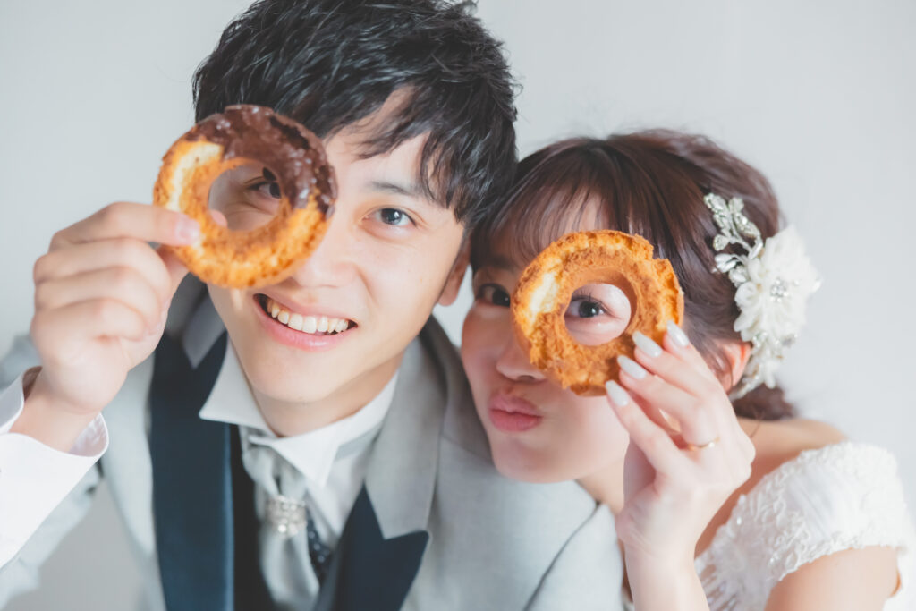 大阪フォトウェディングでドーナツを持って撮影する新郎新婦のアップショット