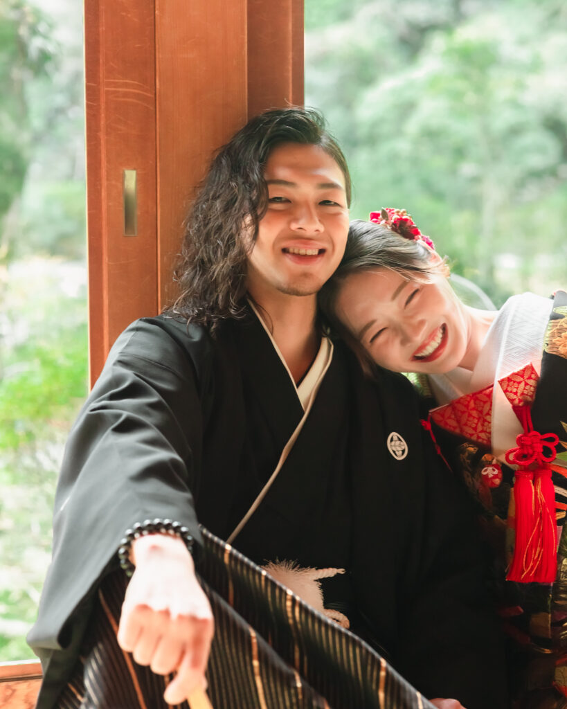 髭とロングヘアが似合う黒紋付の新郎と色打掛の新婦が笑顔で寄り添うフォトウェディング