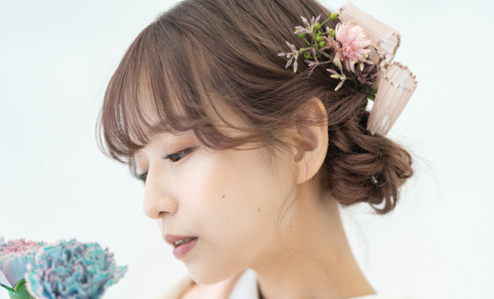 白無垢の洋髪ゆるふわシニヨンに前髪ありとピンクの花を添えた花嫁