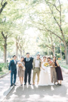 大阪の靭公園の並木通りで友人と一緒にフォトウェディング撮影を楽しむカップル
