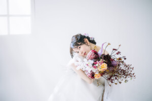 大阪のスタジオで大ぶりのブーケをもちカメラに微笑みかける花嫁