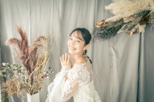 大阪のスタジオでレーススリーブのウェディングドレスをまとう花嫁